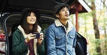 車のトランクに女性と男性が座っている画像