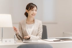 女性がPCの前で話している画像