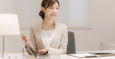 女性がPCの前で話している画像